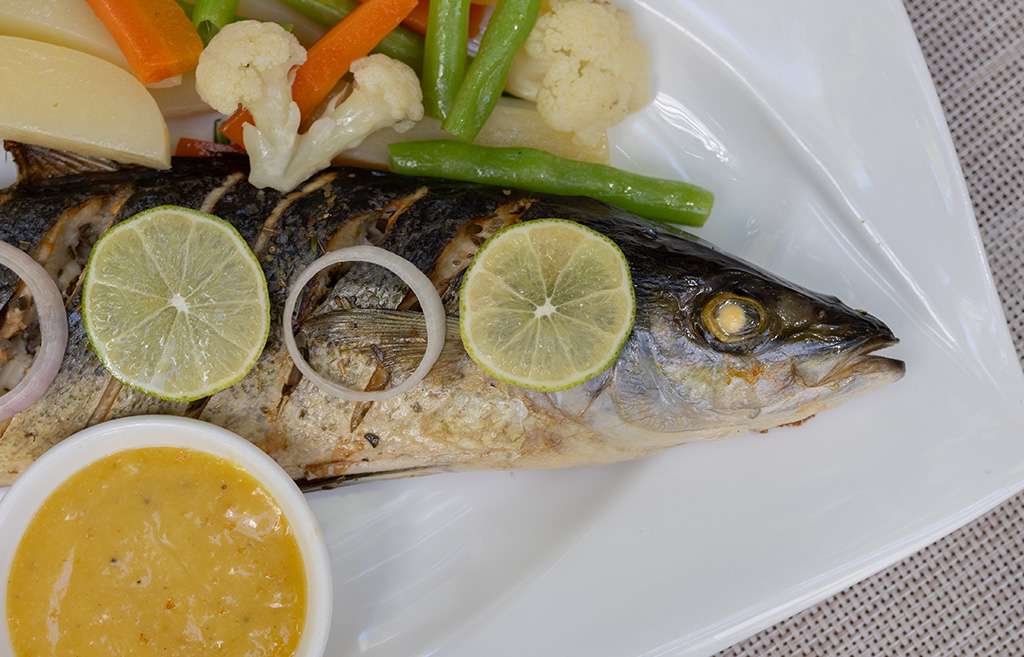 Grilled fish with lime slices, salsa and steamed vegetables; fresh food at the Kamadhoo Inn, Maldives.